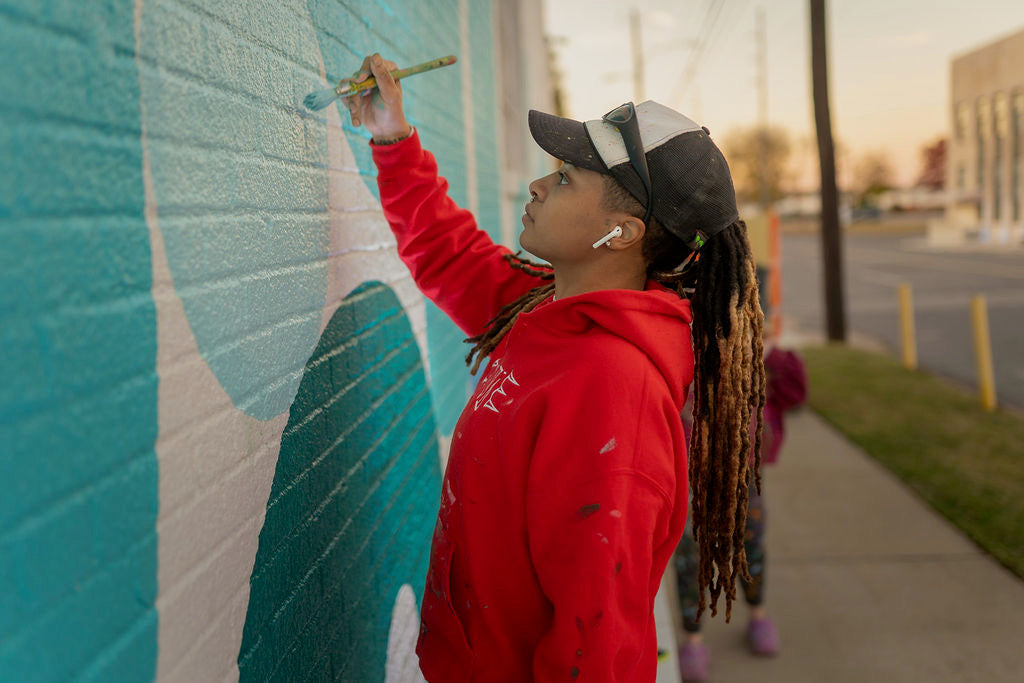 Desireé painting a mural